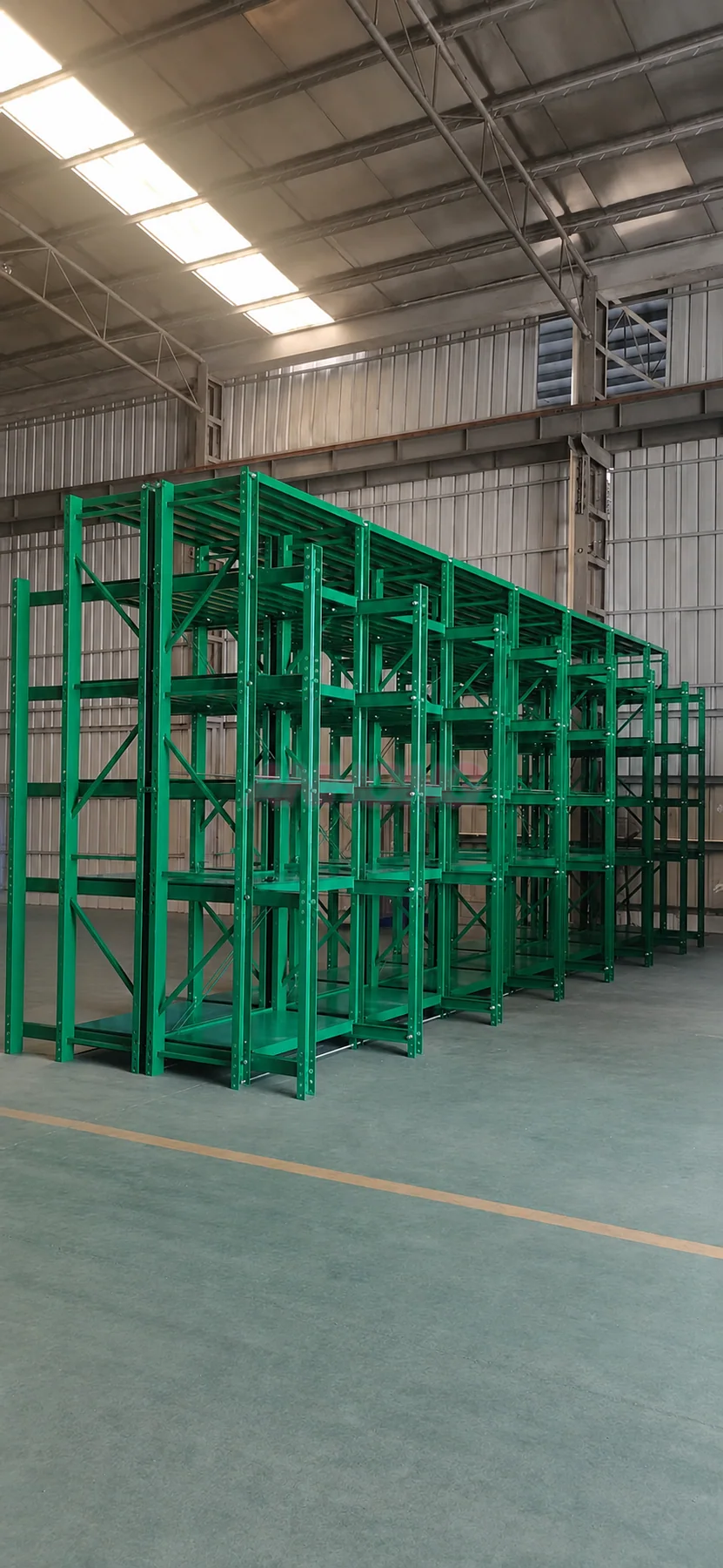 Tall green mold storage racks in a workshop